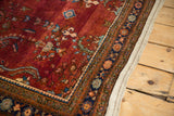 Detail of a vintage Persian Sarouk's burgundy field, intricate navy border, and secure side finish.