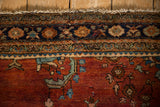 Close-up of the vintage Sarouk's navy floral border, time-softened pile, and secured end.