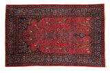Antique Sarouk rug with a red Tree of Life and birds motif, framed by a dark indigo floral border.