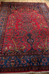 Angled shot highlighting the rich texture and traditional Tree of Life design of a Persian Sarouk rug.