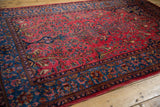 Lustrous wool pile on an antique Sarouk rug showing the raspberry field and dark indigo floral border.