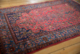 Angled view of an antique Sarouk showing the Tree of Life motif and rich indigo border.