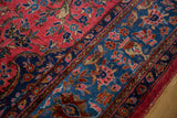 Finely drawn palmettes and rosettes within the sapphire blue border of an antique Sarouk rug.