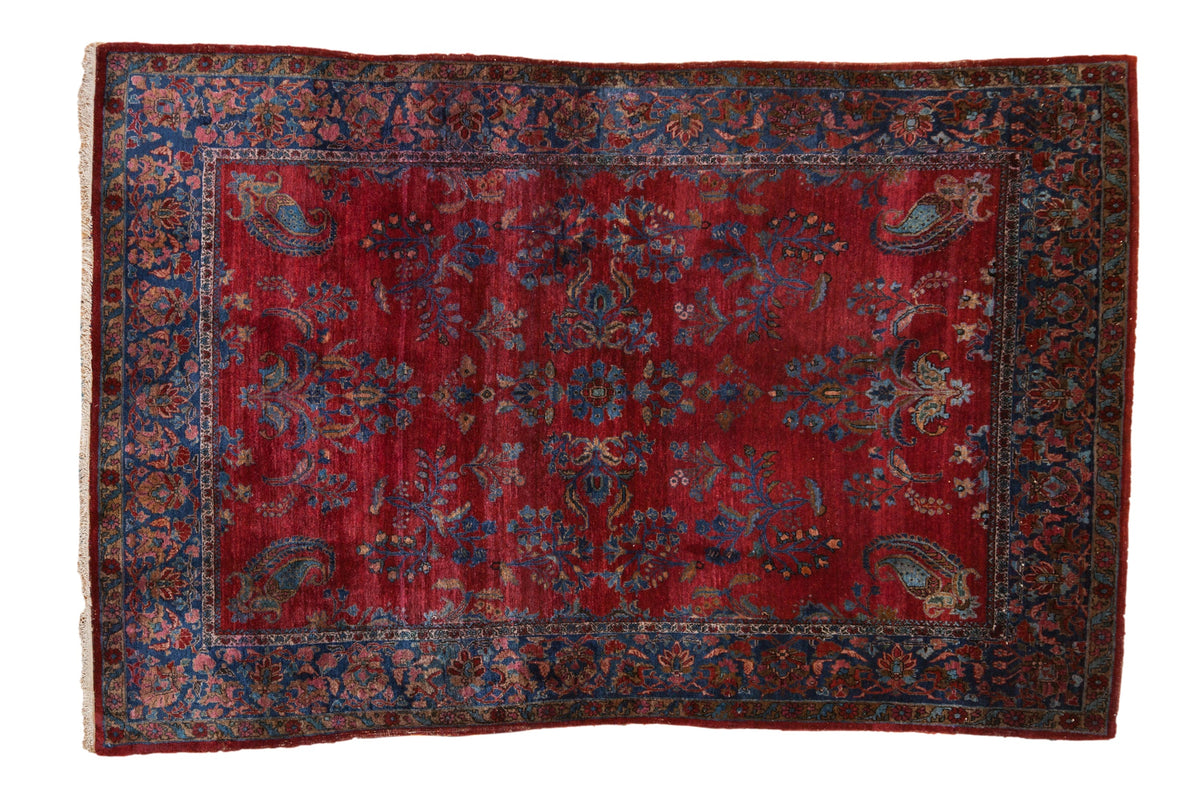 Fine antique Kashan rug with a red floral field, paisley botehs, and a wide sapphire blue border.