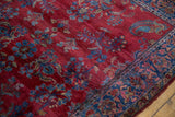 Paisley boteh motif on the ruby red field and sapphire blue border of an antique Kashan rug.