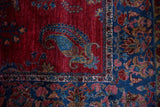 Large paisley boteh and floral border detail on a fine antique Kashan rug in gem-tones.