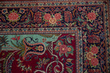 Expressive rose clusters and arabesques on the navy blue main border of a fine Persian Kashan rug.