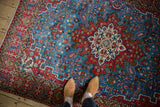 Vintage Persian Qom rug's ivory medallion and cherry red geometric details on a sky blue field.