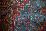 A vintage Persian Qom's refined red border and densely patterned sky blue field.