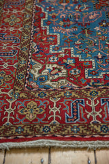 Intricate floral and geometric border in cherry red and gold on a vintage Persian Qom rug.