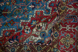 Softly draped vintage Persian rug showing the texture of its tight weave and geometric patterns.