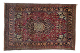 Antique Persian Isfahan rug with a central floral medallion, ivory spandrels, and a deep cochineal red field.