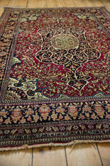 Angled view across an antique Isfahan rug's fine pile, focusing on the central medallion and floral arabesques.