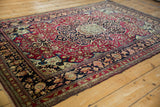 A collector-quality antique Isfahan rug with a classic medallion, red field, and radiating floral arabesques.