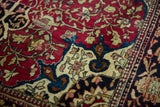 Detail of rich cochineal red and sapphire blue floral arabesques in an antique Isfahan rug.