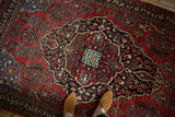 Concentric medallions and floral motifs on a vintage Sarouk rug with a short, dense pile.