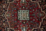 A vintage Sarouk rug's central medallion in powder blue, ivory, and deep brick red.