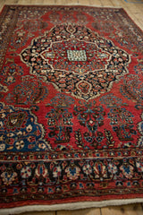 Low angle view of the vintage Sarouk rug's dense pile and concentric medallion design.