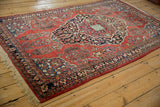 Angled view of a vintage Sarouk rug's asymmetric concentric medallion design.