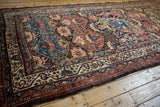 Angled view of the pictorial enthronement scene and Bakhtiari floral motifs on an antique Afshar runner.