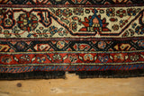Tattered end of a coarse wool antique Afshar runner, with floral borders in indigo, red, and ivory.