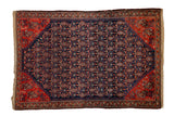 Antique Persian Malayer rug with navy blue field, allover boteh design, and red geometric border.