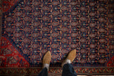 Navy and red boteh pattern with time-softened tones and geometric floral border on antique Malayer rug.