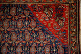 Antique Malayer rug: navy blue boteh field meets a tomato red geometric border.