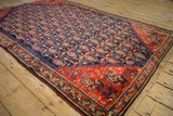 Antique Malayer rug corner, tomato red geometric border, navy boteh field, and worn edge.