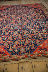 Antique Malayer rug close-up: navy field with staggered botehs, tomato red border, aged selvage.
