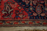 Antique Malayer rug's red, navy, and beige geometric border with visible foundation and fringe.