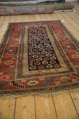 Antique Kurdish Hamadan rug with navy geometric botehs and brick red serrated leaf floral main border.