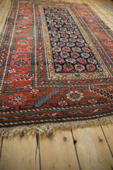 Antique Kurdish Hamadan rug corner with brick red serrated leaf border and navy geometric botehs.