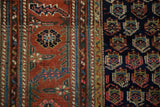 Antique Kurdish Hamadan rug detail: brick red field, vine minor borders, navy geometric pattern.