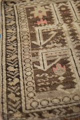 Mostly even wear and geometric border details on a hand-knotted antique Caucasian rug.
