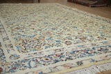 Angled view across the vintage Kashan carpet's mostly even pile, showing delicate floral motifs.