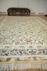 Low perspective across a vintage Kashan carpet's field, highlighting its Rococo-stylized leaves and vines.