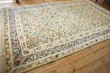 Angled view of the vintage Kashan rug, showing the full sprawling floral pattern.