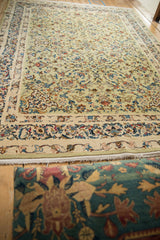Low perspective showing the sprawling floral vines on a vintage Kashan carpet.