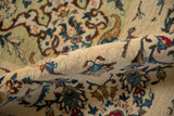 A rolled view of the vintage Kashan carpet highlights its dense, even pile and tight, fine weave.