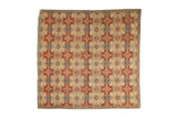 Antique Persian textile with a kaleidoscopic botanical motif in terracotta, sand, and soft sky blue.