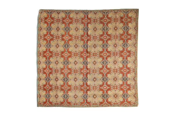 Antique Persian textile with a kaleidoscopic botanical motif in terracotta, sand, and soft sky blue.
