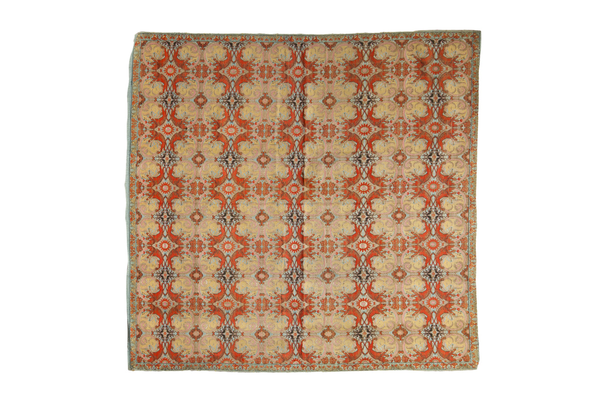 Antique Persian textile with a kaleidoscopic botanical motif in terracotta, sand, and soft sky blue.