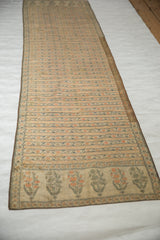 Full length of an antique Persian silk brocade sash, showing its striped pattern and floral ends.