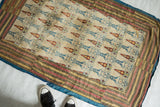 Full view of an antique Persian textile with a figural pattern, illustrating its size and layout.