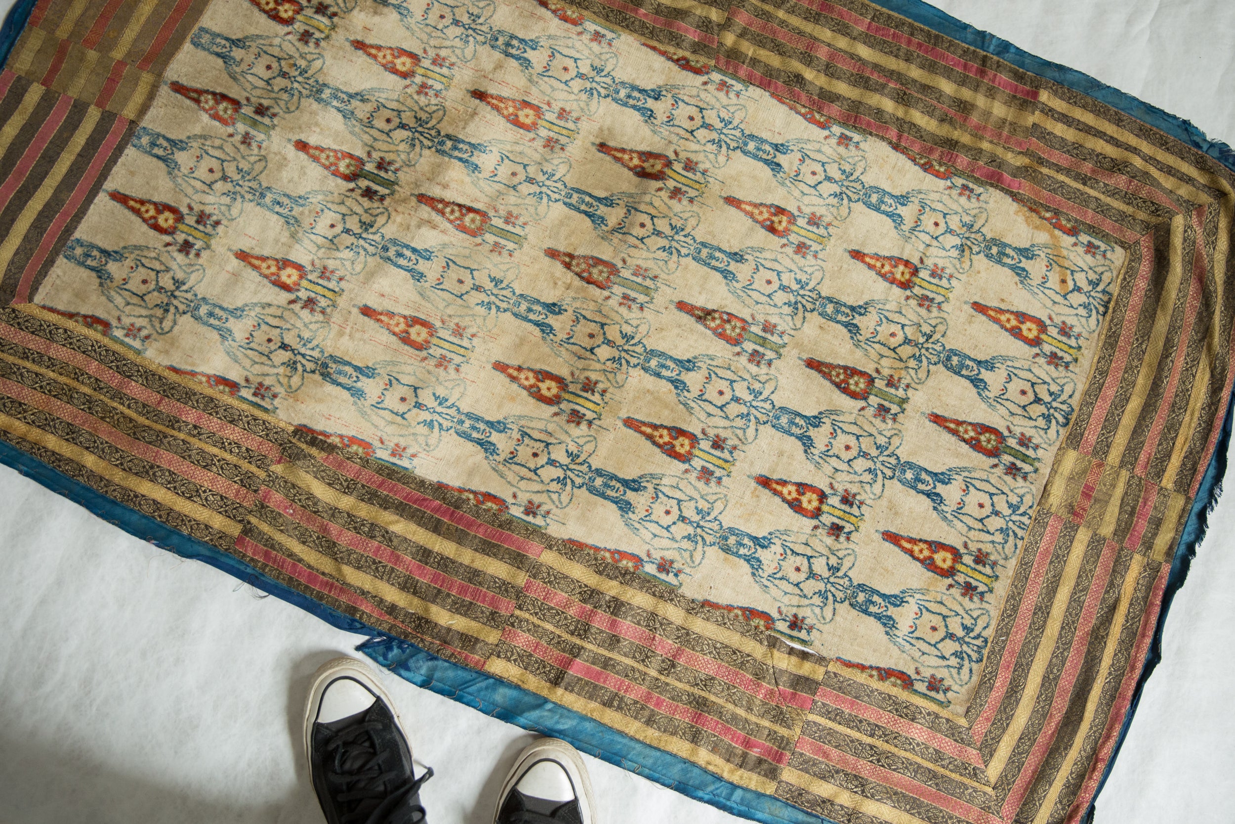 Full view of an antique Persian textile with a figural pattern, illustrating its size and layout.