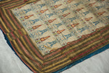 Corner detail of a Persian velvet textile showing the mitered, multi-striped border and blue backing.