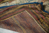 Corner construction detail of an antique Persian velvet textile, showing the striped border and blue edging.