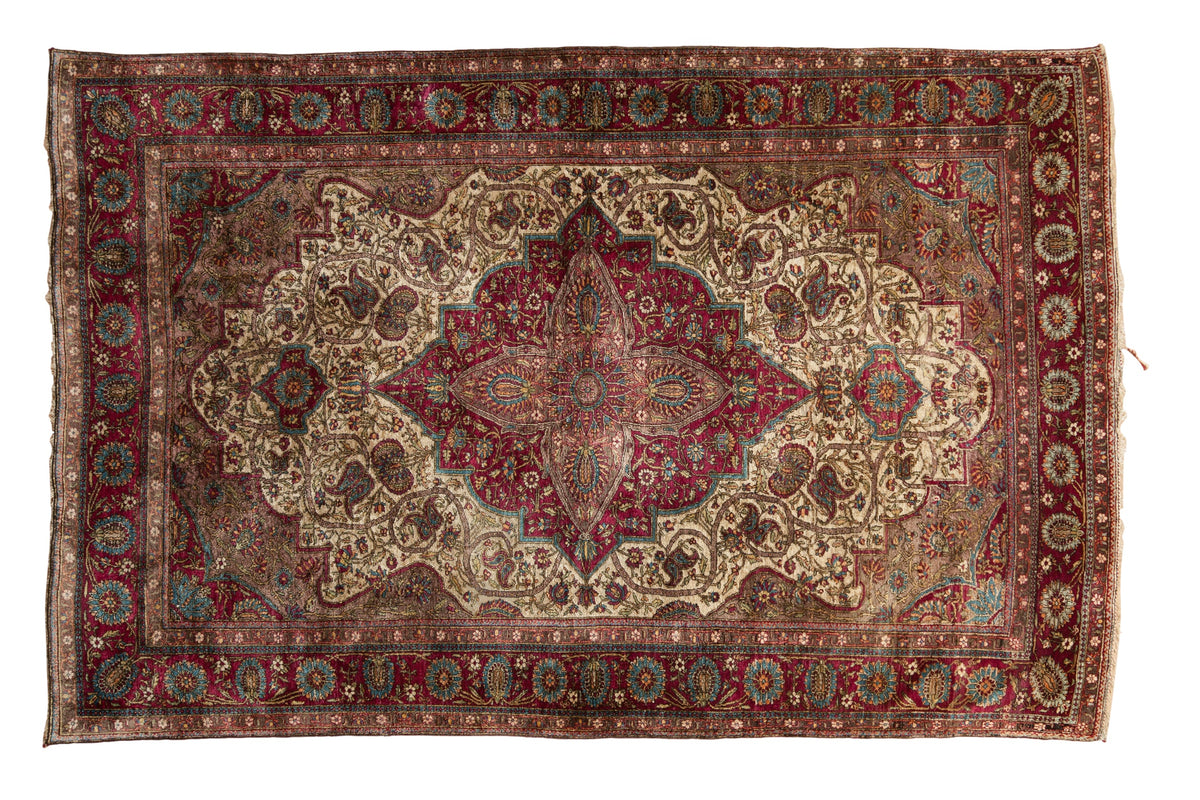 Antique silk Mohtashem Kashan rug with a burgundy shield medallion and scrolling vines on an ivory field.