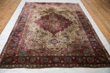 Full angled view of an antique silk Kashan showing its burgundy medallion and ivory floral field.